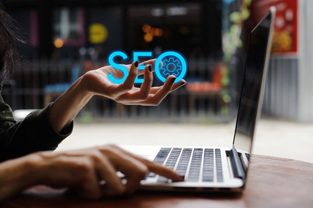 A person interacting with a laptop, with a glowing 'SEO' symbol in hand, symbolizing Eunika Agency’s expertise in search engine optimization and digital marketing strategies.